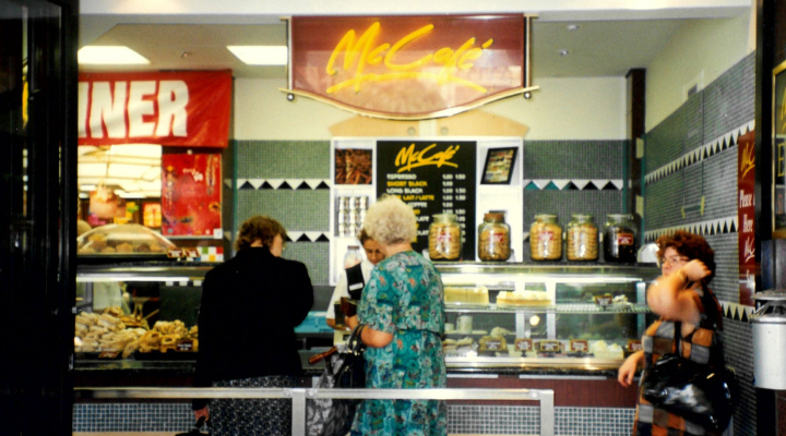 Three people standing at the counter at a McCafe